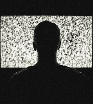 Man sitting in front of TV with static
